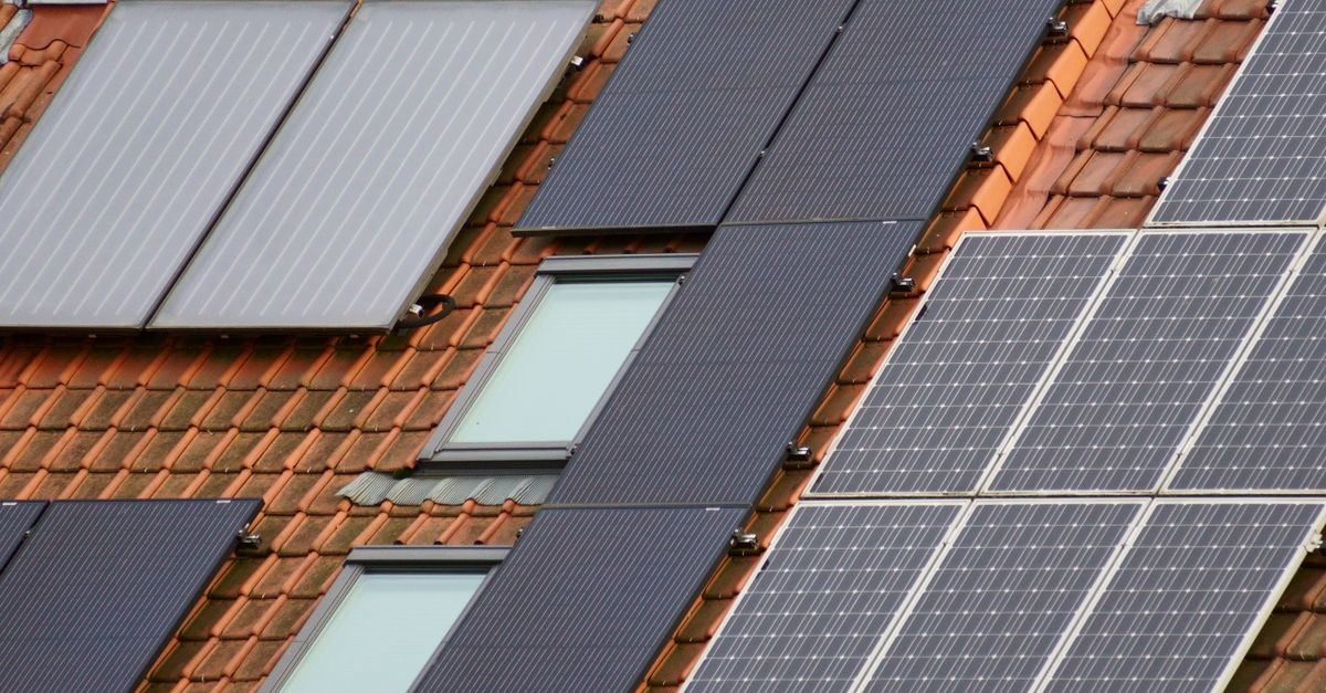 Panneaux solaires photovoltaïques et capteurs thermiques posés sur un toit en tuiles